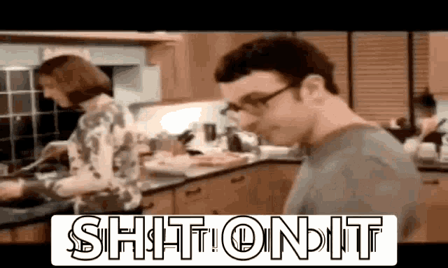 a man and a woman are cooking in a kitchen and the words shit on it are on the screen .
