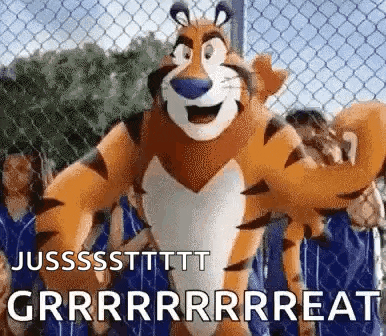 tony the tiger is standing in front of a chain link fence with a crowd of people behind him .