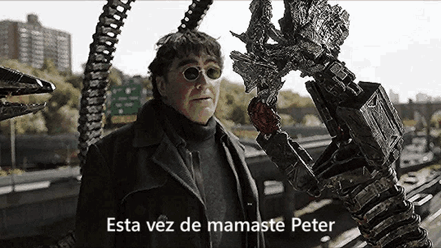 a man wearing sunglasses and a coat is standing next to a robotic arm .