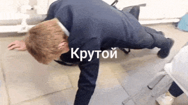 a man in a suit is doing push ups on the floor in russian .