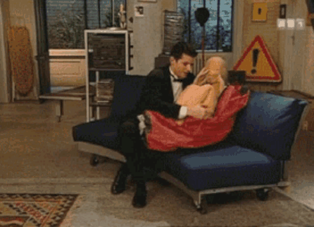 a man in a suit kisses the hand of a blonde woman in a blue dress