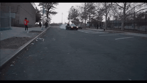 a car driving down a street with smoke coming out of the tires