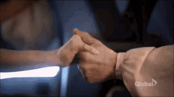 a man and a woman are holding hands in a hospital bed .