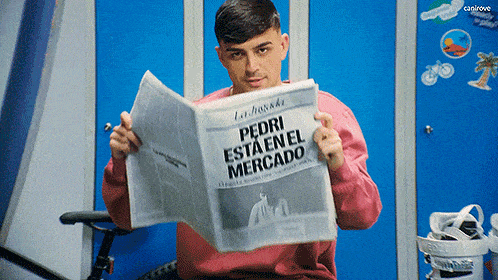a man in a pink sweater is reading a newspaper titled pedri esta en el mercado