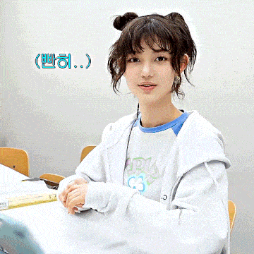 a girl is clapping her hands in front of a sign that says ' korean '