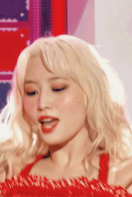 a close up of a woman 's face with blonde hair and red lipstick .