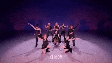 a group of women are dancing on a stage with the word choom in the background