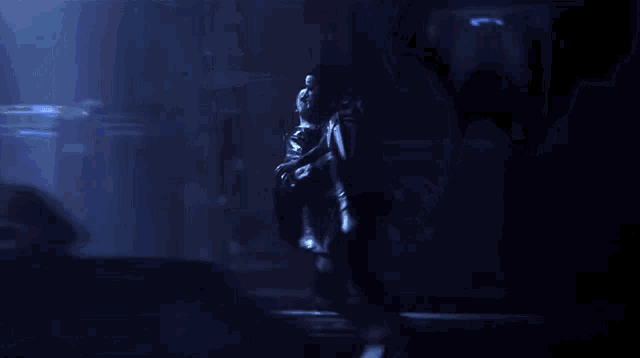 a person in a dark room with a blue light shining on them