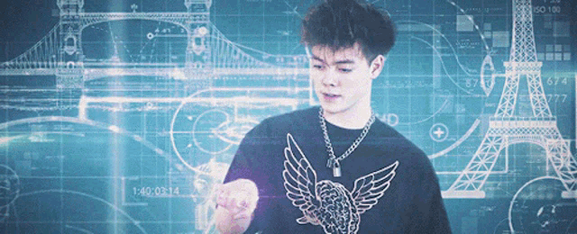 a young man wearing a black shirt with an eagle on it stands in front of a drawing of the eiffel tower