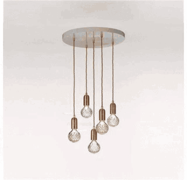 a brass chandelier with white glass globes hanging from the ceiling