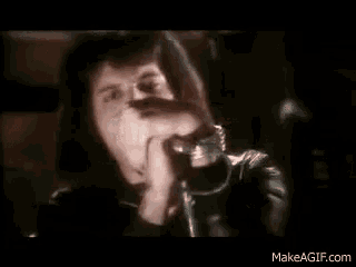 a man is singing into a microphone while wearing a ring .