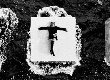 a black and white photo of a woman floating on a piece of paper