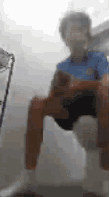 a blurry picture of a person sitting on a chair in a room .