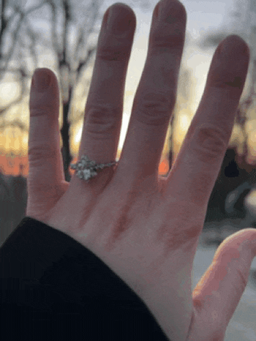 a close up of a person 's hand with a ring on their finger
