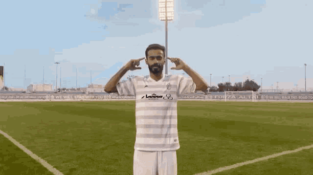 a man with a beard wearing a white and black striped shirt with the number 18 on it