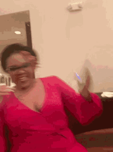 a woman in a red dress and glasses is holding a cell phone