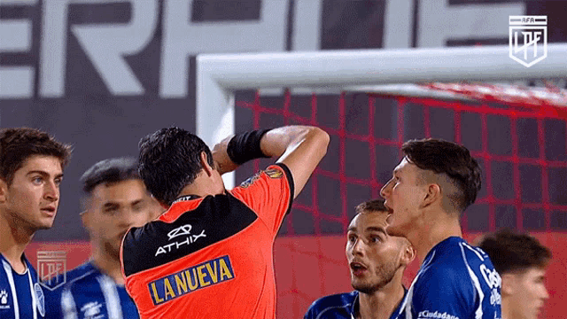 a soccer player wearing an orange shirt that says lanueva on the back