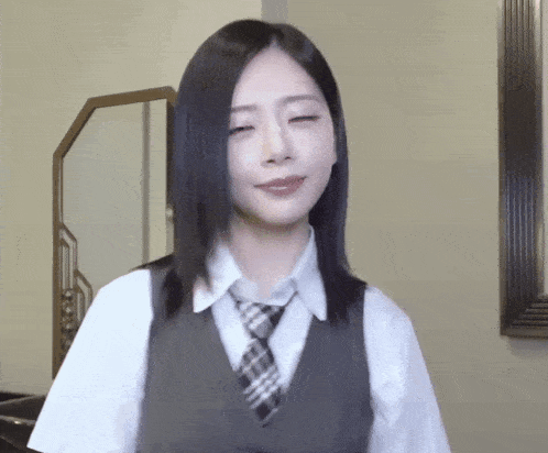 a woman with her eyes closed wearing a white shirt and tie