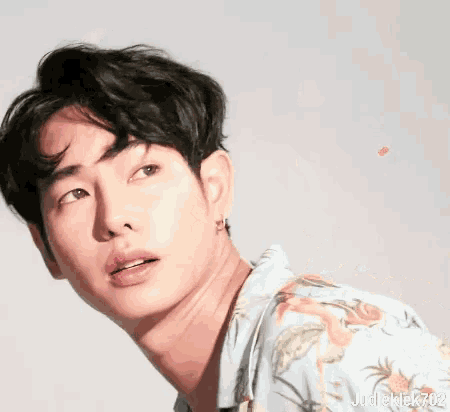 a close up of a man 's face with his eyes closed and a pink heart above his head