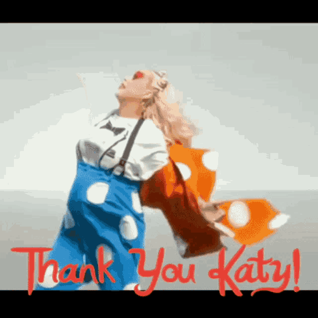 a woman in a clown costume is holding an orange and white polka dot scarf and says thank you katy