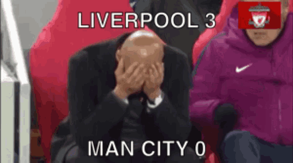 a man covering his face with his hands while sitting in a liverpool 3 man city 0 stadium seat