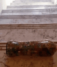 a bottle is sitting on a marble floor in front of stairs