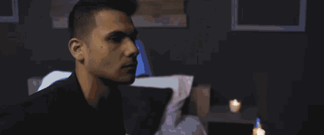 a man in a suit is standing in a dark room holding a piece of paper .
