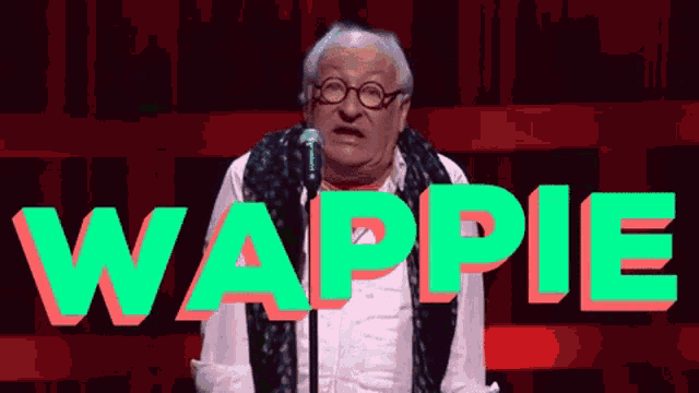 an older man stands in front of a microphone with the word wappie in green letters