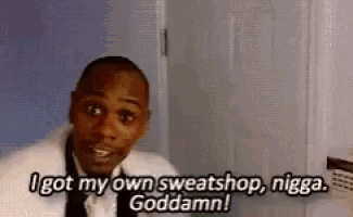 a man in a suit and tie is standing in front of a door and talking about his own sweatshop .