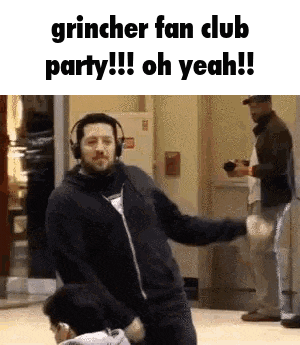 a man wearing headphones is dancing in front of a group of people in a room .