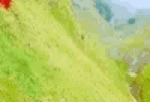 a red triangle is sitting on top of a hill .