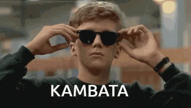 a man wearing sunglasses with the word kambata on the bottom right