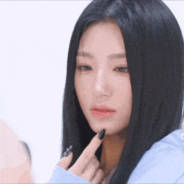 a woman with long black hair and black nails