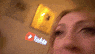 a close up of a woman 's face with a youtube logo behind her