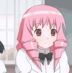 a girl with pink hair and a black bow tie is sitting in a classroom with other students .
