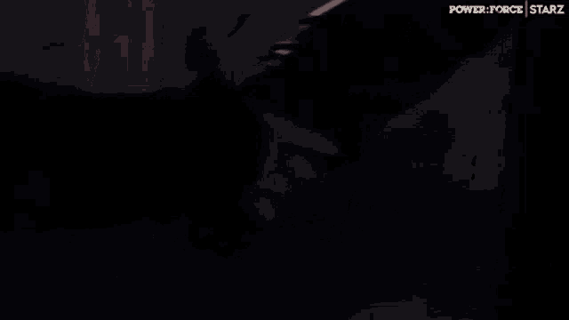 a man with long hair and a beard is talking to another man in a dark room .