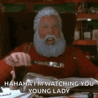 a man with a beard and mustache is sitting at a table with a knife in his mouth .