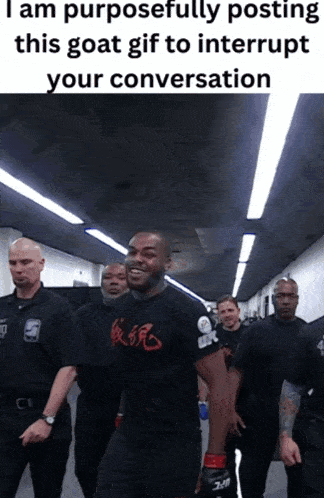 a man in a black shirt that says ' ufc ' on it walks down a hallway