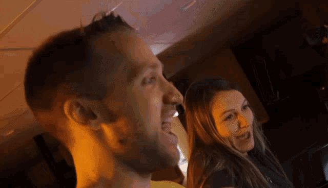 a man and a woman are standing next to each other and the man is smiling