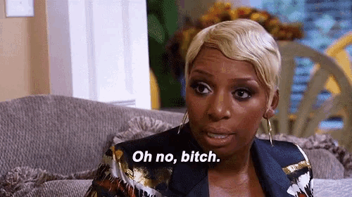 a woman is sitting on a couch and saying oh no bitch .