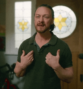 a man in a green shirt is giving a thumbs up