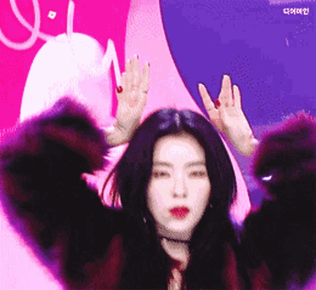 a woman wearing a fur coat is waving her hands