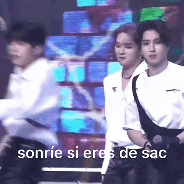 a group of men are standing on a stage with the words sonrie si eres de sac on the bottom right