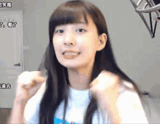 a girl with long hair and a white shirt with chinese writing on the bottom right