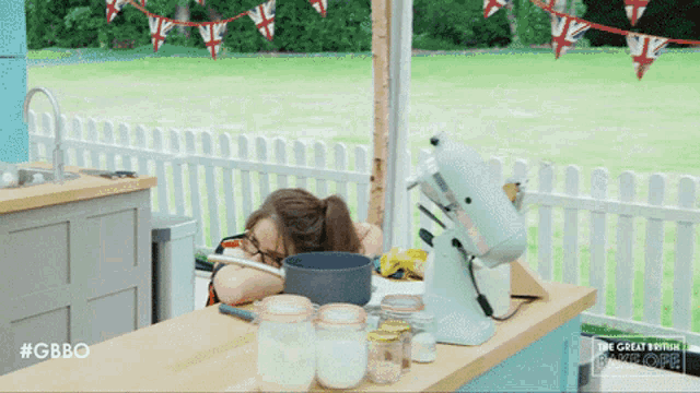 a woman sleeping in a kitchen with the great britain logo