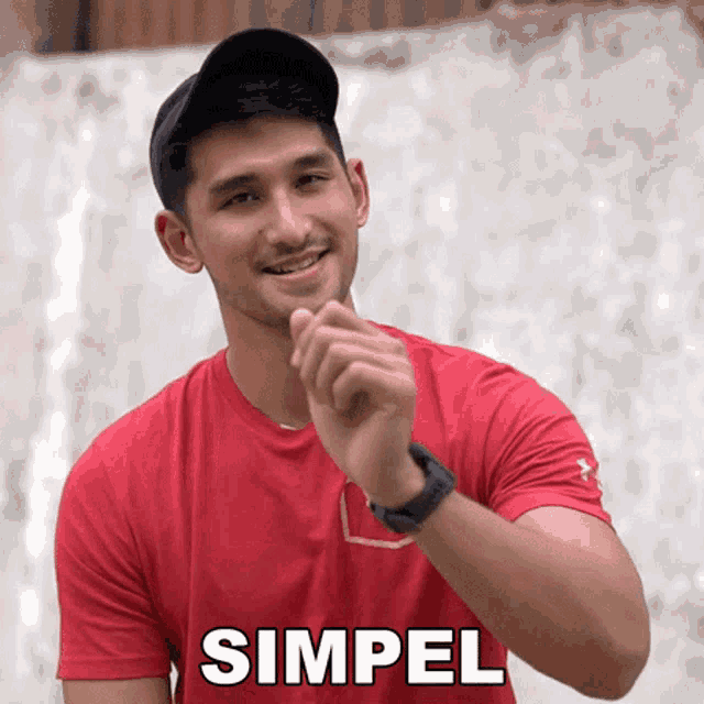 a man wearing a red shirt with the word simpel on the front