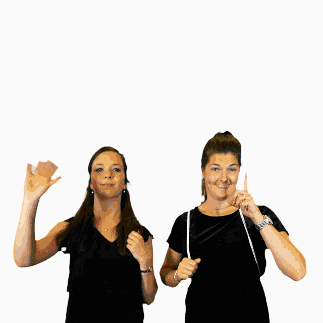 two women are standing next to each other and one of them is holding a measuring tape