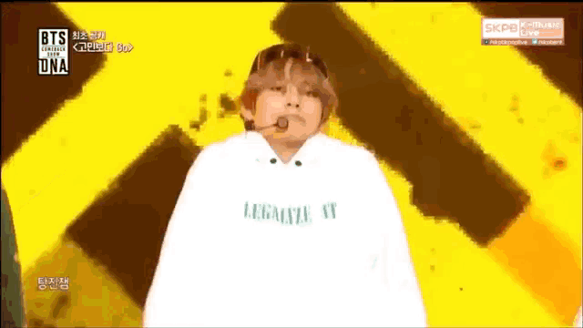 a person wearing a white hoodie that says ' i love you ' on it is standing on a stage .