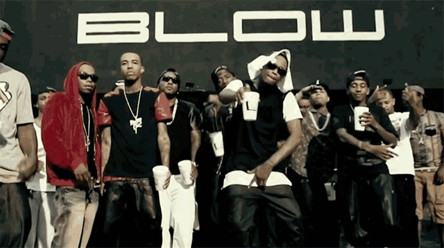 a group of young men are standing in front of a blow sign