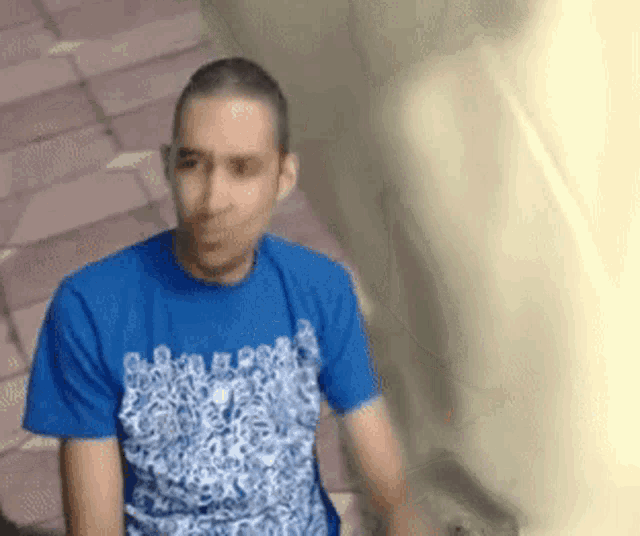 a man wearing a blue t-shirt that says ' a ' on it